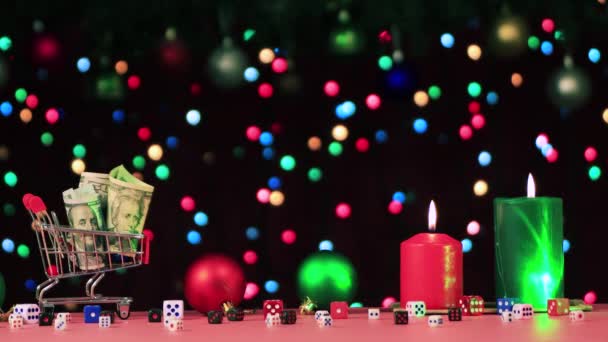 Een mand met geld, kerstspeelgoed en brandende kaarsen met een bewegende groene straal. — Stockvideo