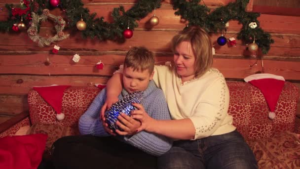 De jongen en zijn moeder kijken naar de blauwe kerstkegel. — Stockvideo