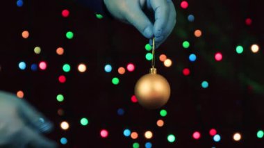 Erkek eller, tıbbi eldivenlerle, bir oyuncak göster - altın bir Noel balosu.