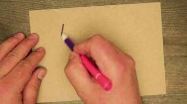 Erkek el, keçeli kalemle karton bir çarşafa kutsal bir gece yazar..