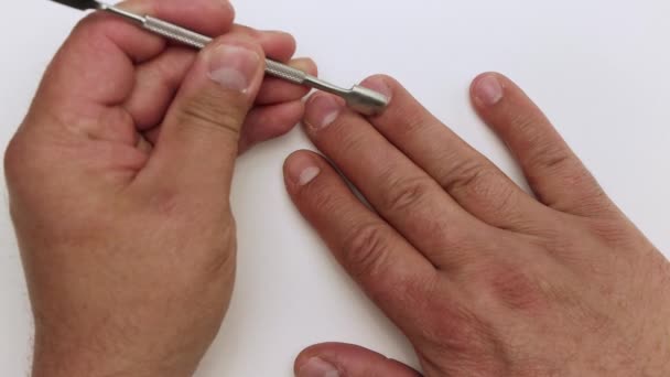 Mann aus nächster Nähe behandelt Nagelhaut mit Spachtel. — Stockvideo