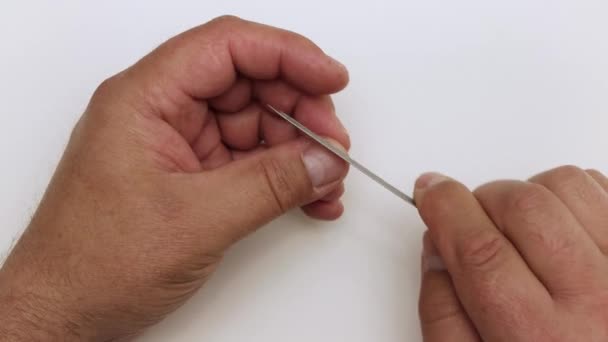 Un hombre en primer plano procesa un clavo con una lima en el dedo. — Vídeos de Stock