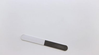 Bir adamın eli tırnak törpüsü, kazıyıcı ve sopa takar..