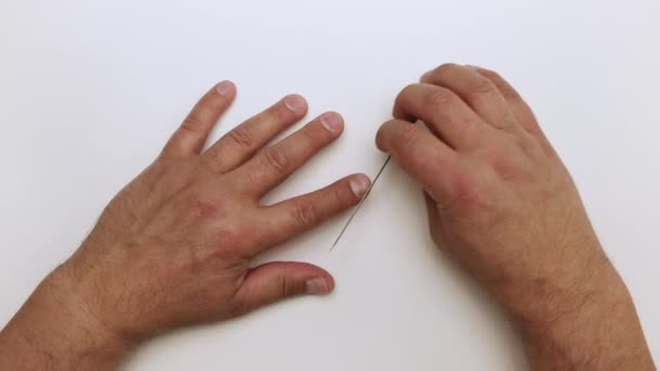 Close-up man verwerkt een nagel met een metalen bestand. — Stockvideo