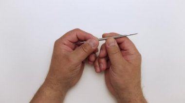 Yakından bir adam bir metal çıkarıcı tutuyor ve gösteriyor ki....