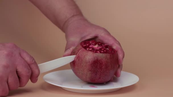 Le mani maschili tagliano lentamente la buccia di un melograno maturo. — Video Stock