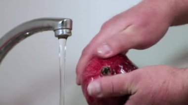 Erkekler hızlı bir hareketle bordo taşlarını parmaklarıyla yıkarlar.. 