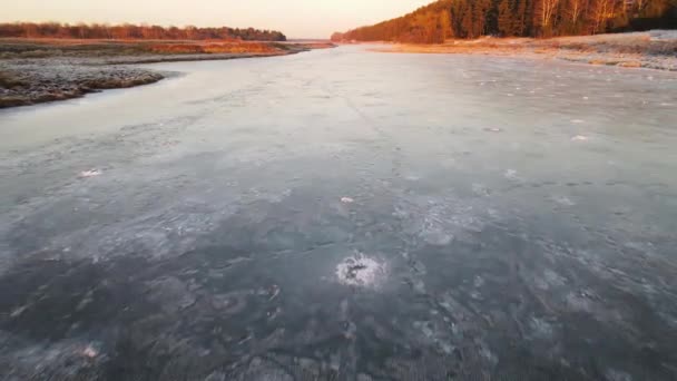 Быстрый полет над замерзшим водоёмом с отпечатками ног на льду. — стоковое видео