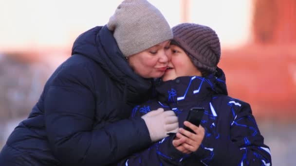 Retrato de una madre feliz con su hijo abrazándose y besándose. — Vídeos de Stock