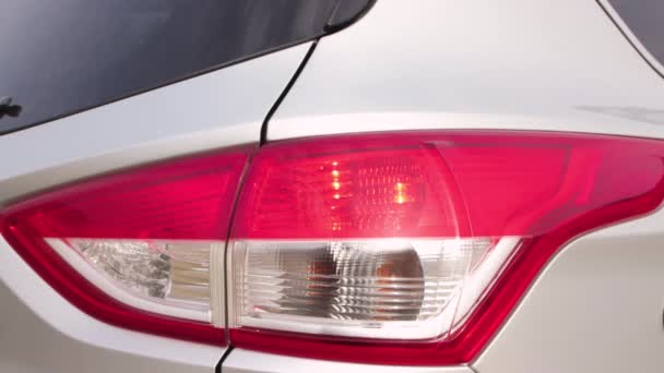 Close-up achterlichten van een witte auto komen aan. — Stockvideo