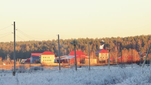 Mehrere Hütten am Rande eines Feldes mit frostigem Gras. — Stockvideo