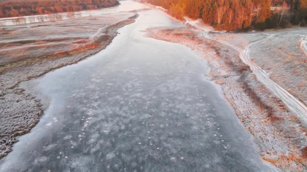 Hoge vlucht over het oppervlak van een bevroren reservoir met oranje gras. — Stockvideo