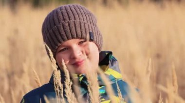 Oğlanlar uzun otların üzerinde yüzyüze gelir, bakar ve gülümser..