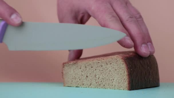 Manliga händer skär rågbröd i bitar med en slow motion. — Stockvideo