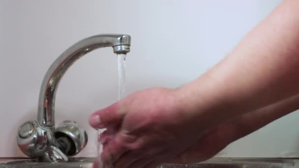 Männerhände öffnen das Wasser und schäumen zwischen den Fingern. — Stockvideo