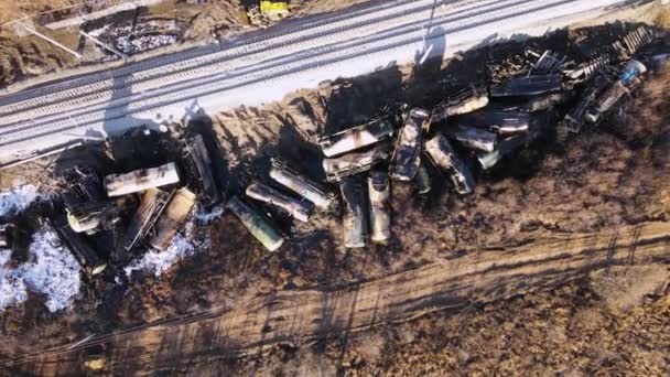 Обломки поезда на железной дороге, разбросанные танки, электрические провода видны. — стоковое видео