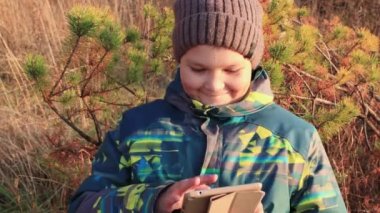 Çocuk gülümsüyor, internetteki tablete bakıyor, parmağını oynatıyor..