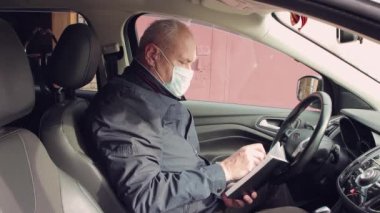 Arabadaki bir iş adamı deftere bir şey yazmış..