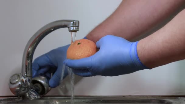 Le mani maschili in guanti lavano il mandarino arancione con una spazzola e un sapone. — Video Stock