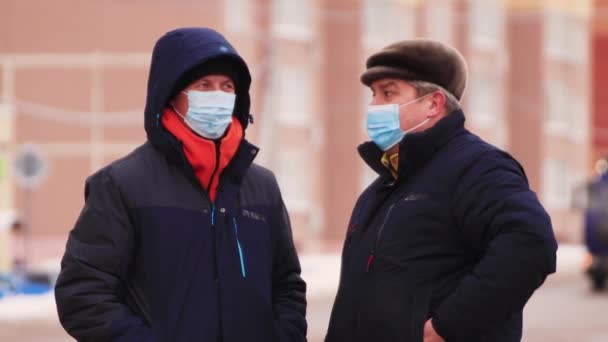 Dwóch zamaskowanych mężczyzn rozmawia podczas pandemii koronawirusa.. — Wideo stockowe