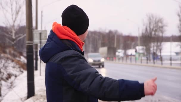 Homme caucasien avec moustache et barbe levé la main pour faire de l'auto-stop. — Video