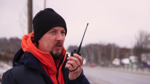 Kaukasische jongeman aan het praten op een walkie-talkie close-up. — Stockvideo
