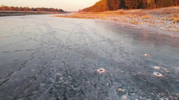 Низкий полет над замерзшим водоёмом со следами на льду. — стоковое видео