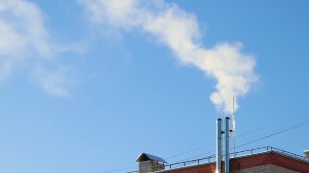 El humo blanco sale de una chimenea en el tejado de la casa.. — Vídeos de Stock