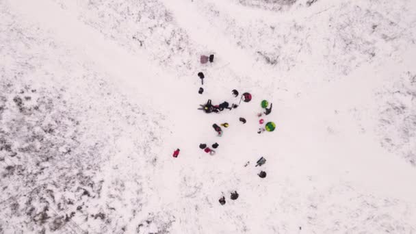 成年人和孩子们都坐在充气雪橇上滑倒在滑梯上 — 图库视频影像