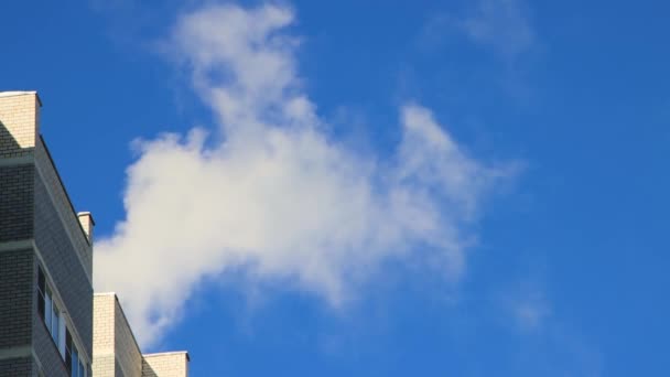 El techo de una casa alta sobre la que el humo vuela rápidamente como nubes blancas — Vídeos de Stock