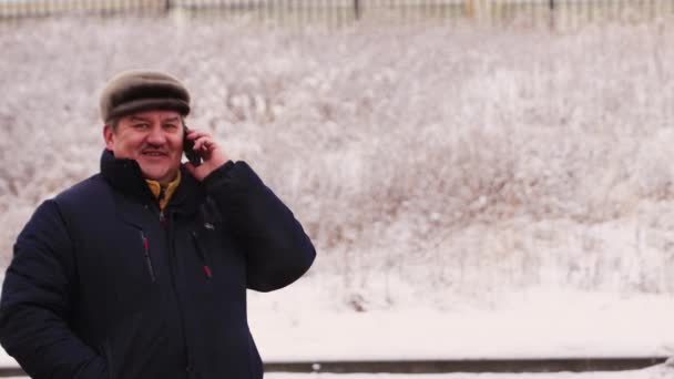 El hombre está felizmente hablando por teléfono y sonriendo. — Vídeos de Stock