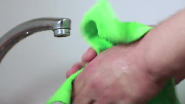 Мужские руки вытирают зеленым полотенцем.. — стоковое видео