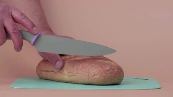 Las manos masculinas ponen pan blanco y lo cortan en rodajas. — Vídeos de Stock