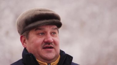 Konuşan ve gülümseyen ciddi bir adamın yakın çekimi.. 