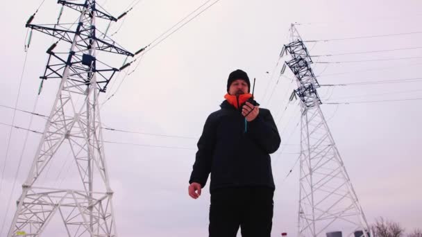 De mannelijke bewaker rookt en houdt een walkietalkie in zijn hand. — Stockvideo