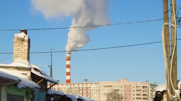 Dym emanuje z komina nad miastem jak puszyste, białe chmury kumulujące — Wideo stockowe