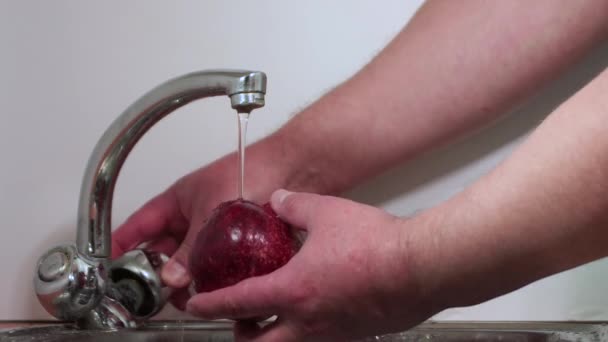 Las manos masculinas lavan granada roja antes de comer. — Vídeo de stock