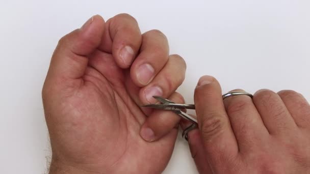 Mão de homem de close-up corta um prego com pequena tesoura. — Vídeo de Stock