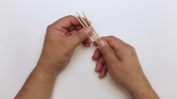 Las manos masculinas demuestran palos de naranja para la manicura y la eliminación de cutículas. — Vídeos de Stock
