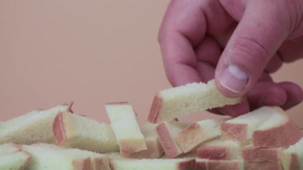 Een mensenhand neemt en toont zelfs plakjes wit brood — Stockvideo