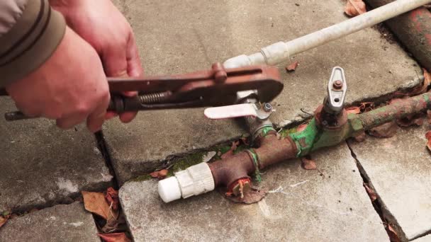 Mãos masculinas desconectam tubos de metal umas das outras com uma chave ajustável. — Vídeo de Stock