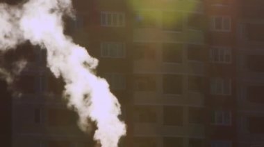 Duman evin arka planında dar beyaz bir derede yükseliyor.