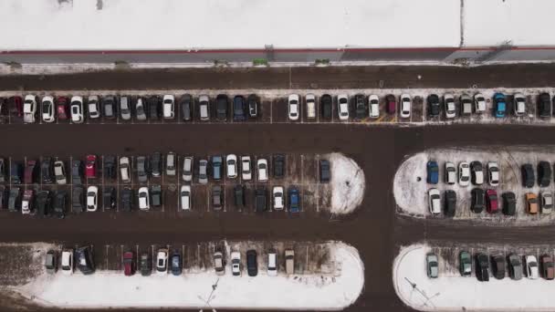 Τα επιβατικά αυτοκίνητα στέκονται σε ευθείες σειρές σε ένα πάρκινγκ το χειμώνα. — Αρχείο Βίντεο