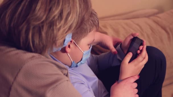 Gelukkig vrouw met haar zoon in een masker door smartphone online bestellen. — Stockvideo