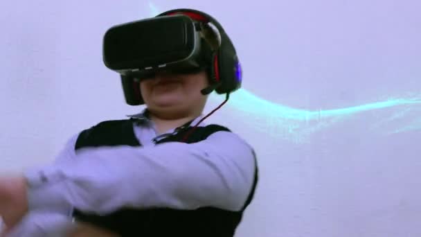 En pojke i ett augmented reality-headset och hörlurar dansar upphetsande. — Stockvideo