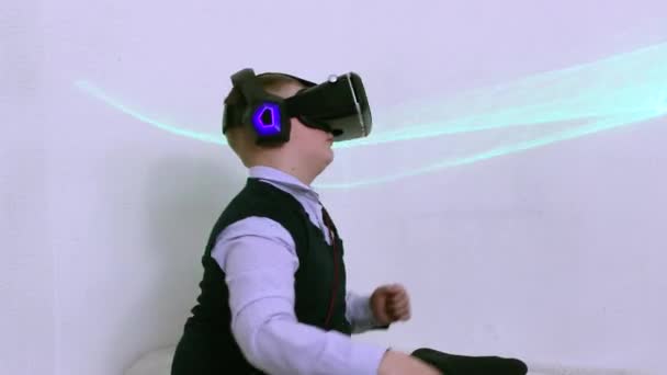 Egy fiú kiterjesztett valóság headset és fejhallgató ül vidáman táncol. — Stock videók