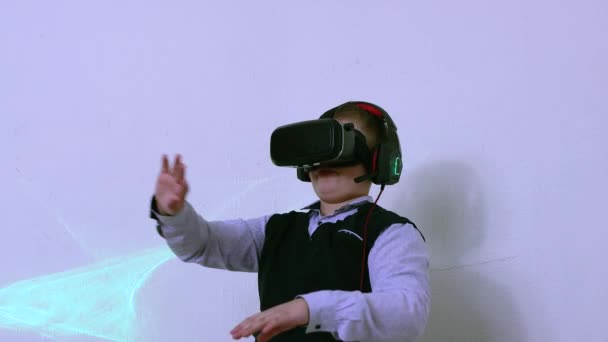 拡張現実のヘッドセットとヘッドフォンの遊びで幸せな男の子. — ストック動画