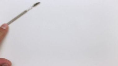 Bir el masaya bir sökücü, makas, meme ucu ve tırnak törpüsü koyar.. 