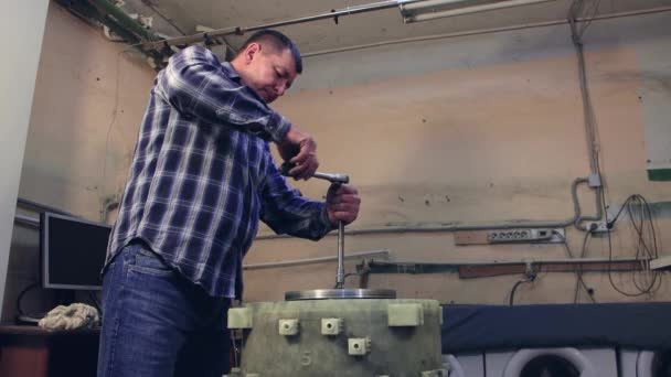 The man tightens the screw on the item from above with a socket wrench. — Stock Video