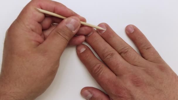 Un primer plano de un palo naranja elimina la cutícula del dedo anular. — Vídeos de Stock